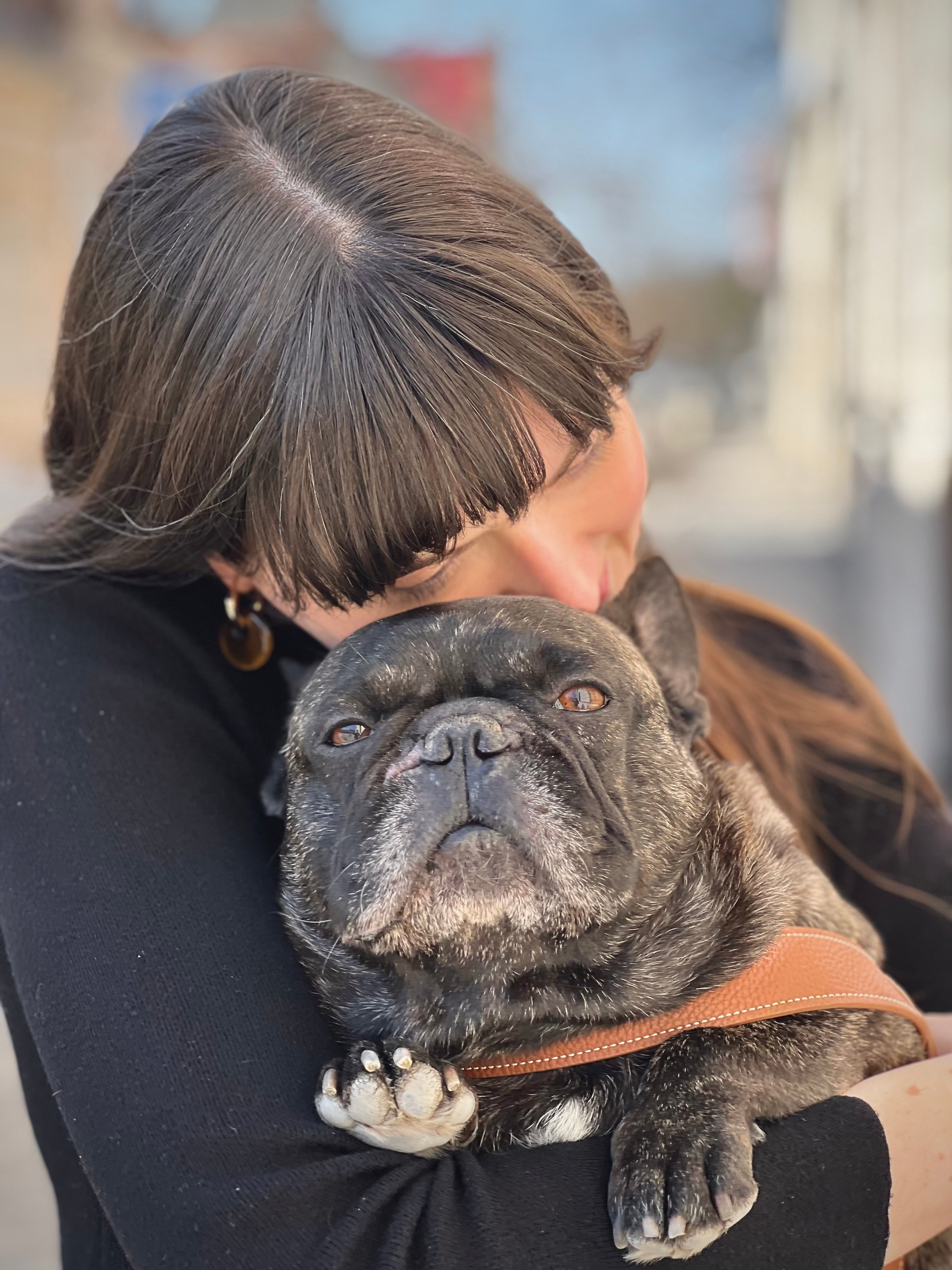 Woman cuddling with a french bulldog