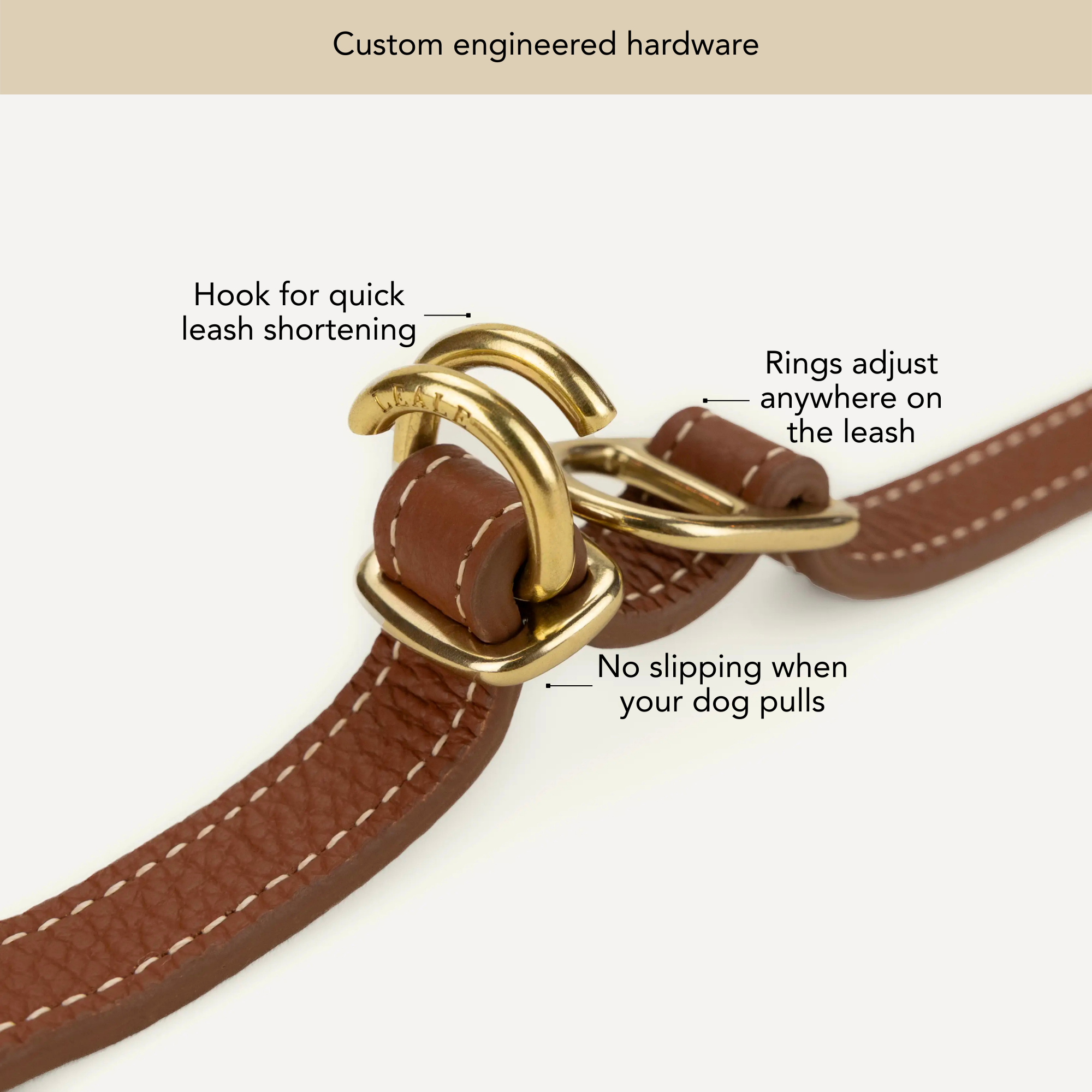 Brown leather dog leash with gold hardware on a white background, labeled for features. #lang_en