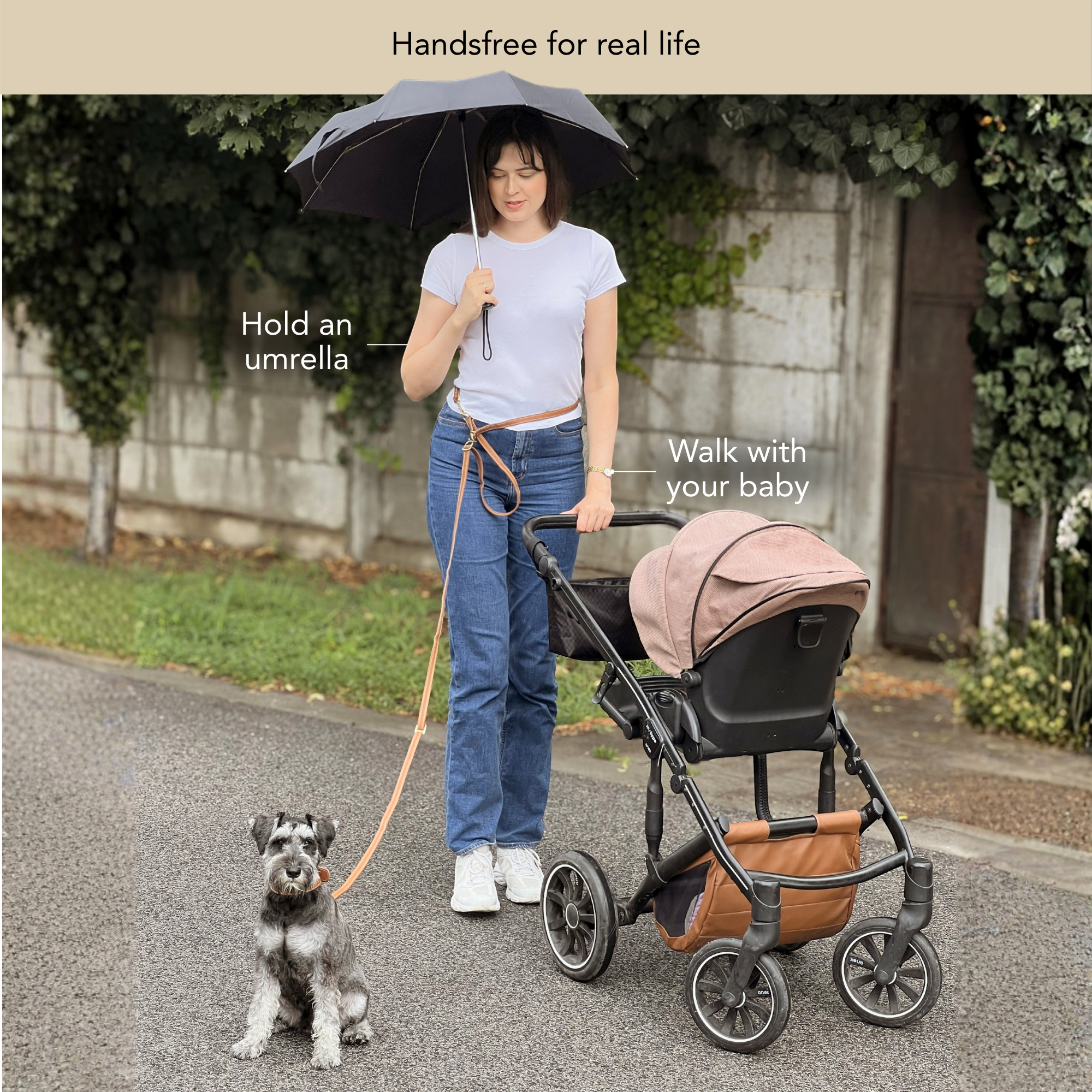 Woman walking with a baby stroller, holding an umbrella, and a dog on a handsfree leash. #lang_en
