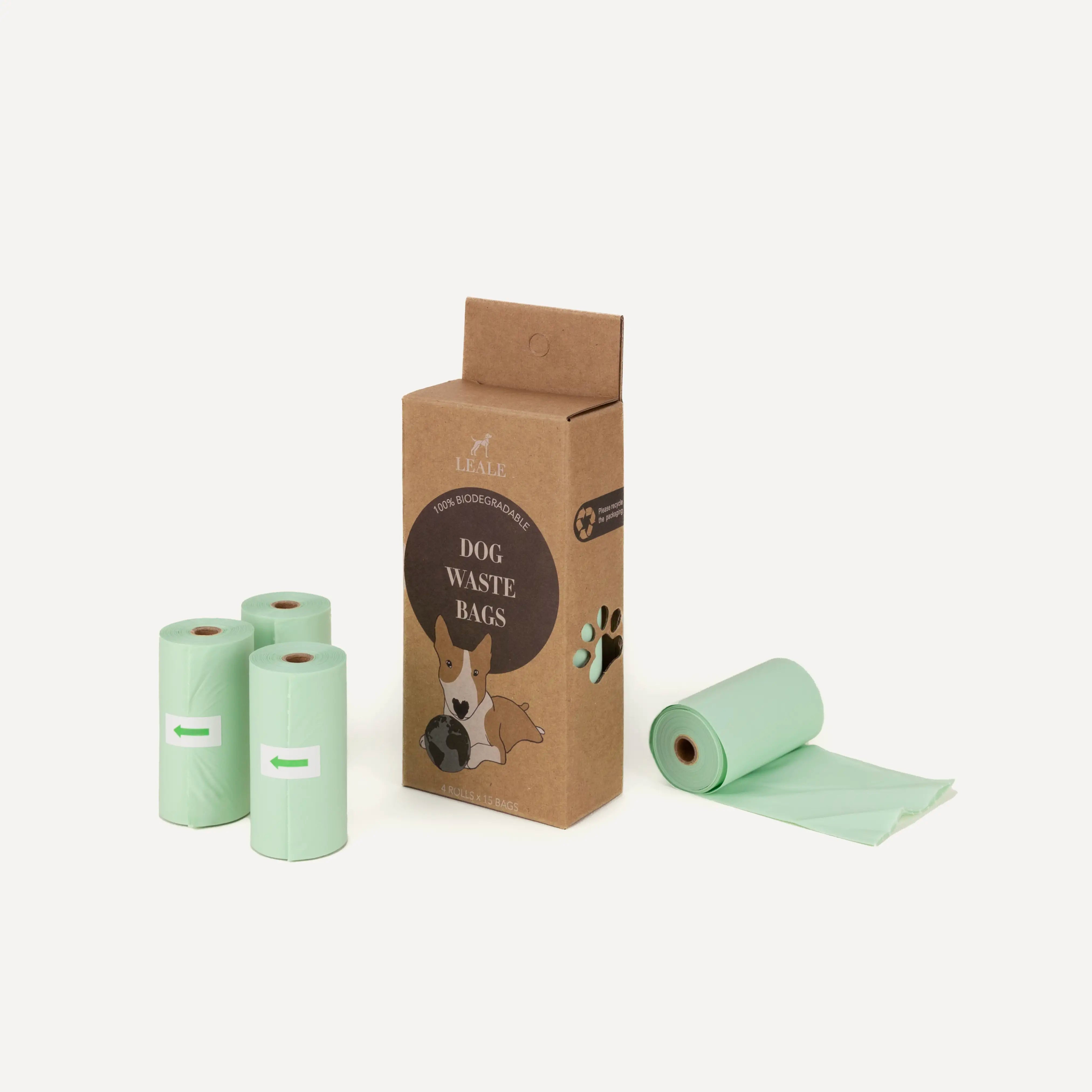 Product image of a cardboard box of biodegradable dog waste bags, next to it the rolls of turquoise waste bags, on a white background 