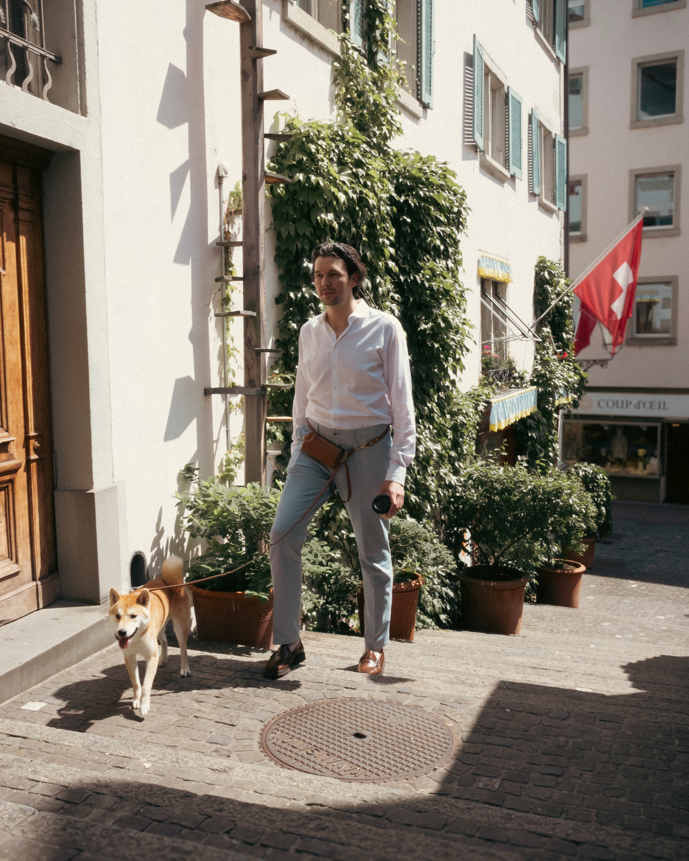 Man walking up the stairs in an old town with a dog